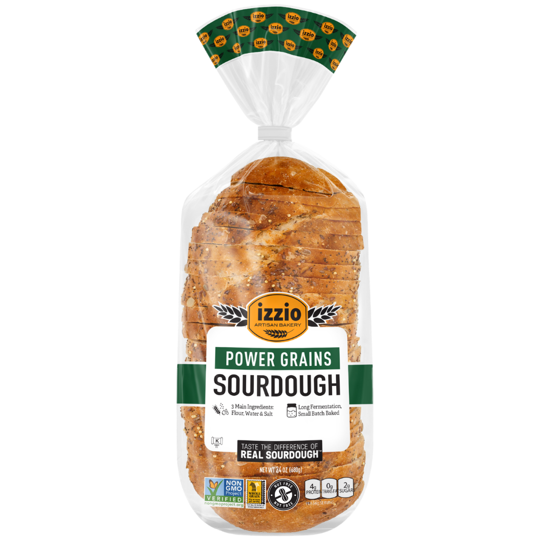 A loaf of Izzio Power Grains Sourdough bread in a clear plastic bag with a green and white label and a green patterned top seal, shown on a plain white background.